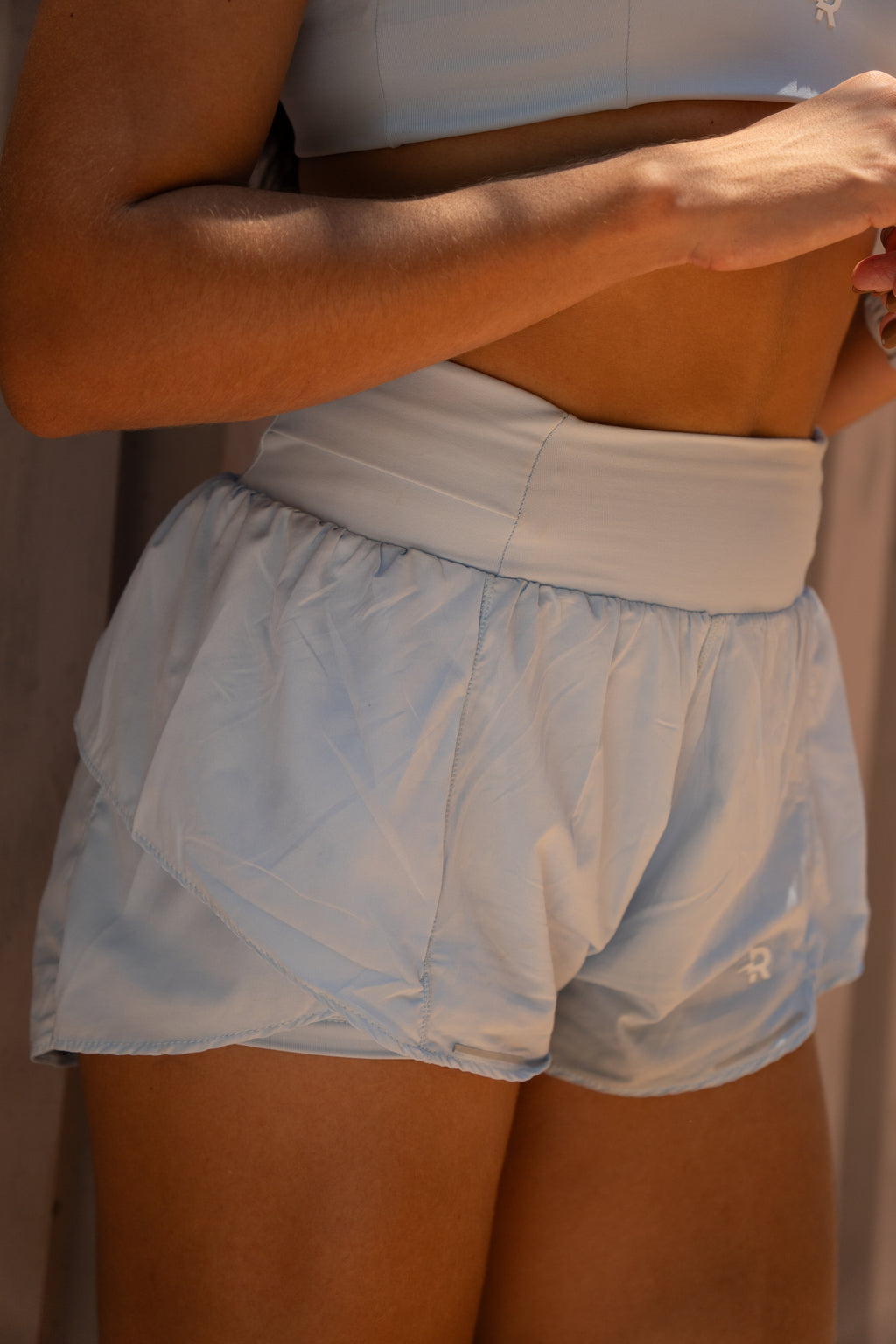 Short Duplo Yris feminino Runaholic, cor azul, detalhe do short visto de costas
