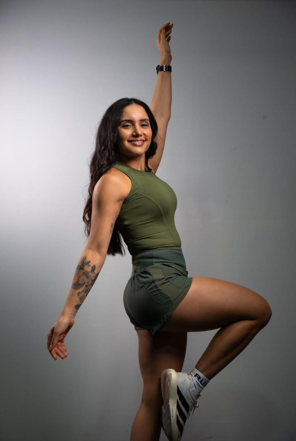 Regata de Compressão feminina Runaholic, cor verde-musgo, modelo em movimento