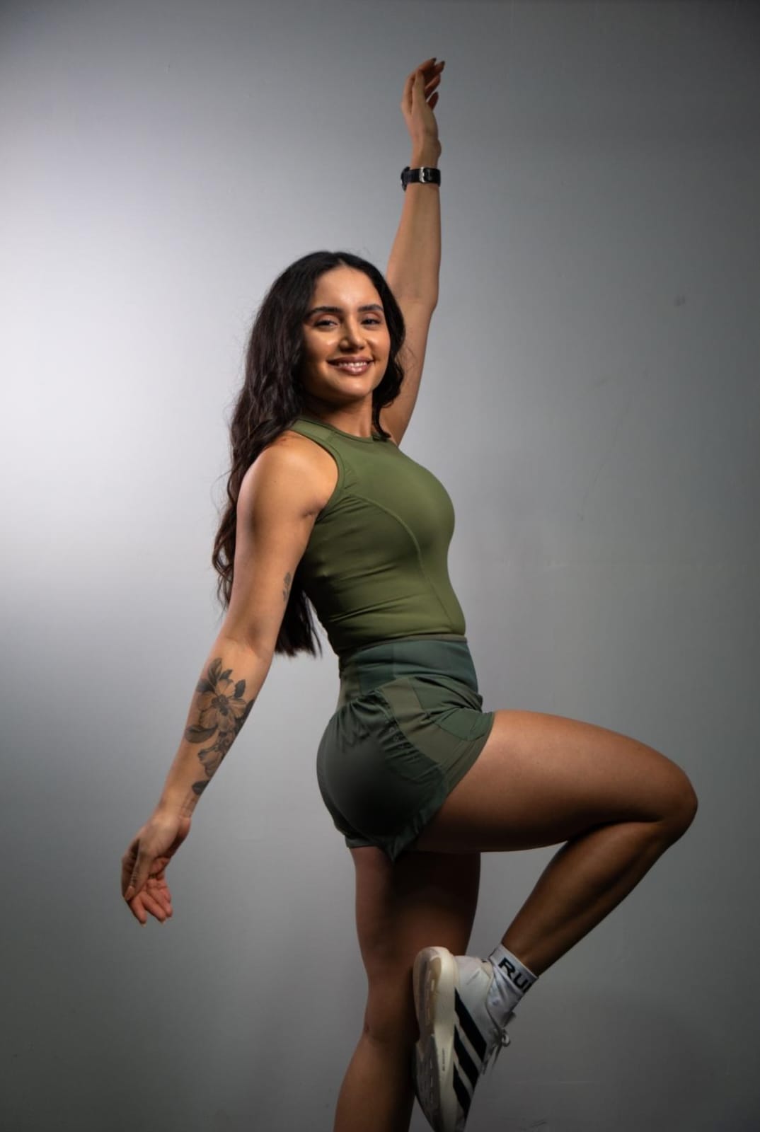 Regata de Compressão feminina Runaholic, cor verde-musgo, modelo em movimento